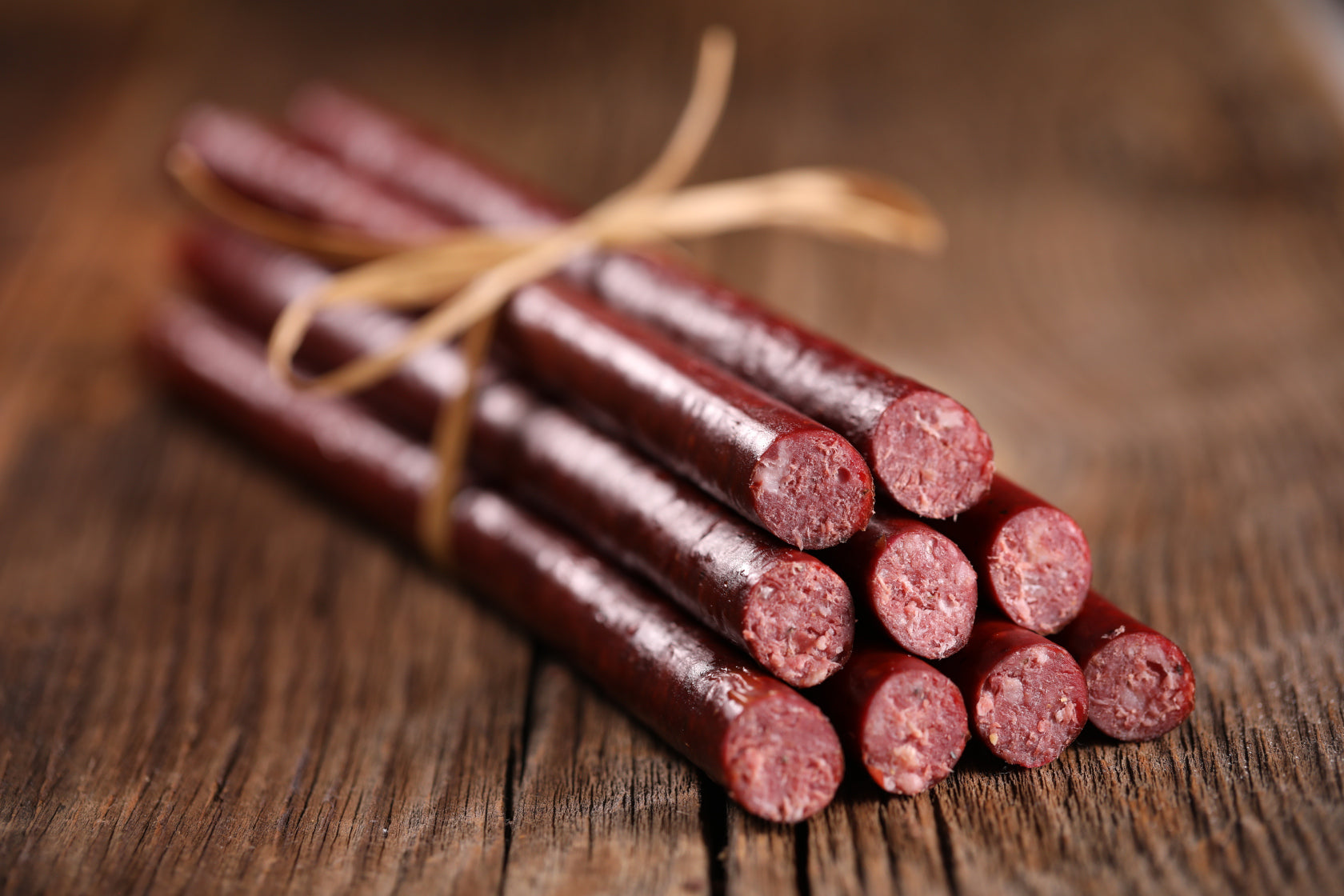 A bundle of beef sticks, held together by butcher's twine.