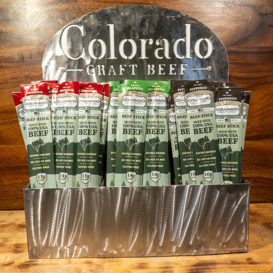 Display of Colorado Craft Beef packages on a wooden surface with a wooden background.
